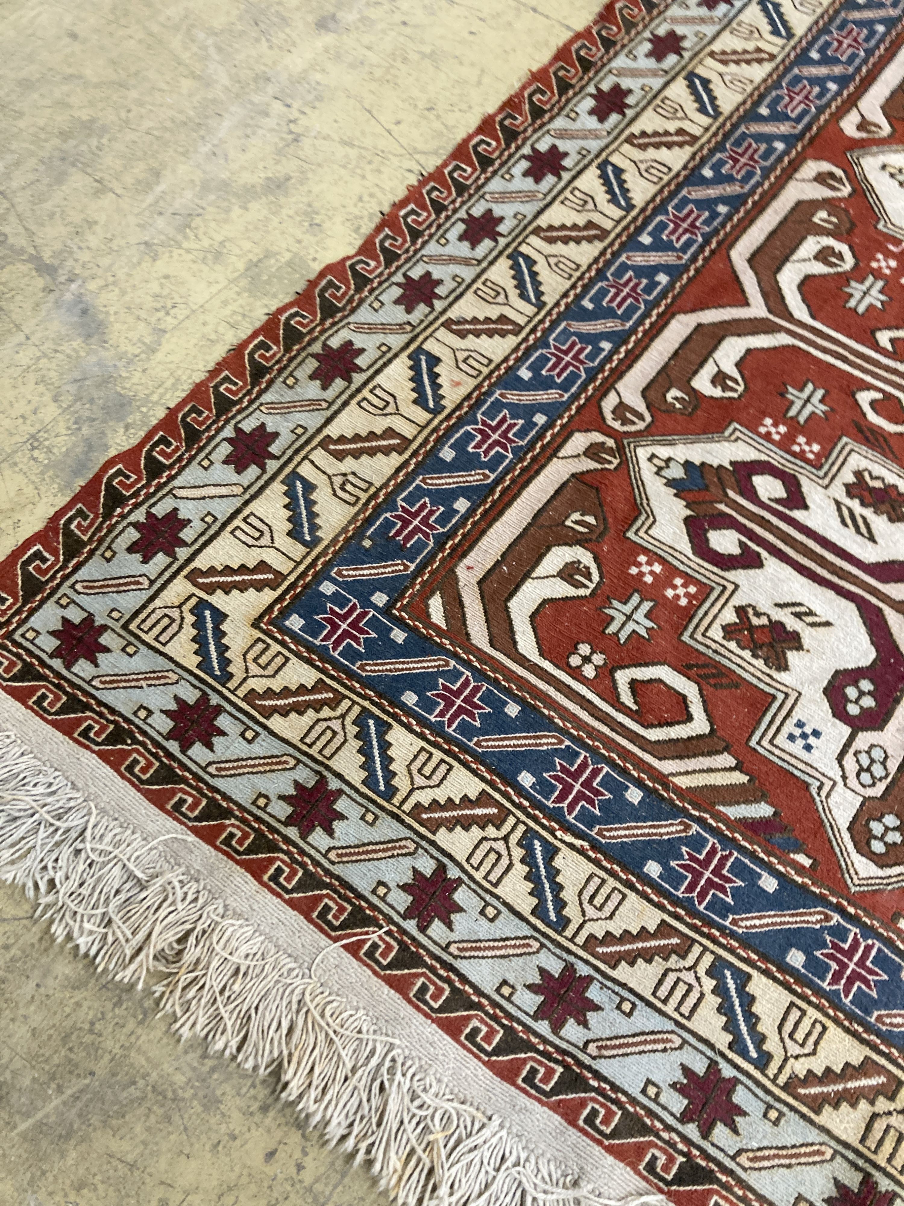 A Caucasian design red ground rug, 240 x 165 cms.